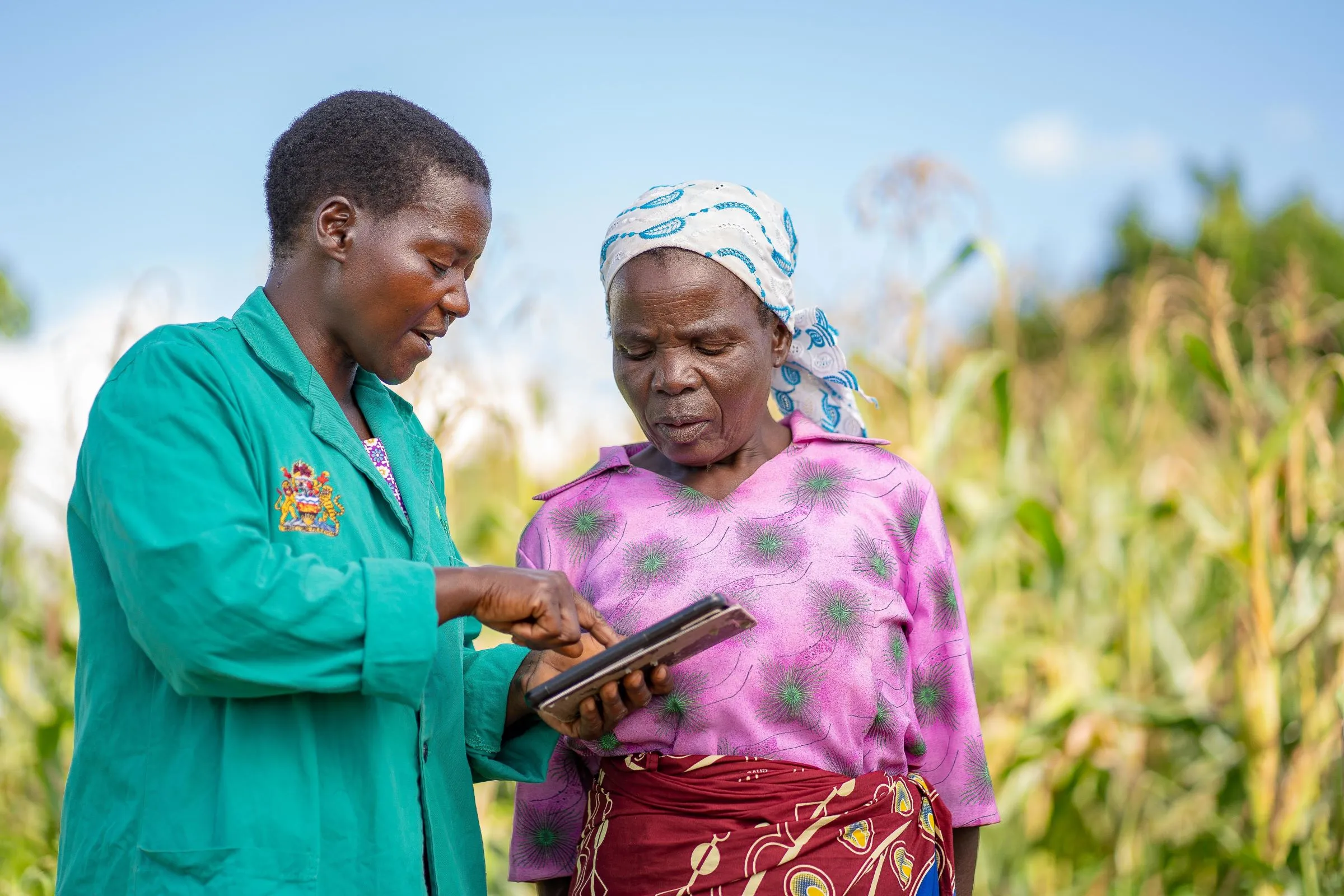An advisor holding a tablet discussing with a farmer