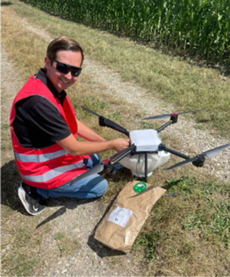 Man in pink high-vis loading Trichogramma capsules into a drone